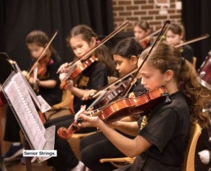 students in strings enseble playing violins